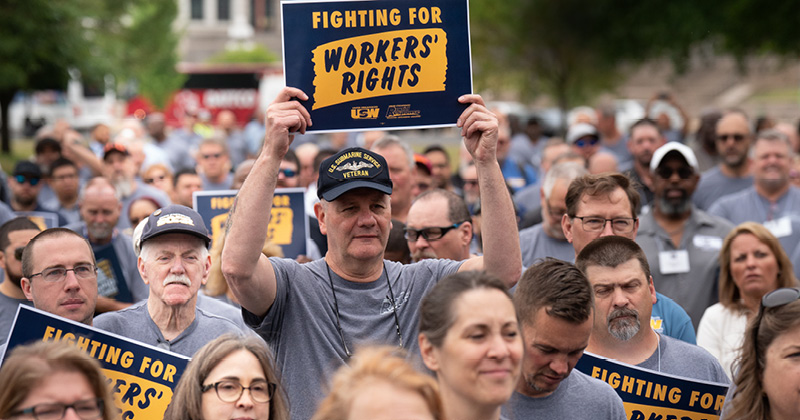 Crowd of use supporters holding signs for worker's rights